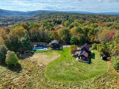 Three buildings across five private acres, featuring a pollinator meadow, heated pool, hot tub, outdoor shower, two grills and fire pit.