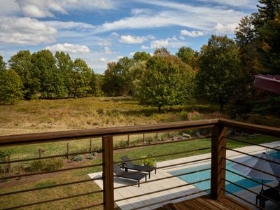 A view of the meadow and pool from the second story deck of the guest house.