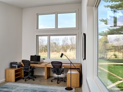 This dedicated work space for remote work has a monitor, printer and peaceful views looking out onto the meadow.