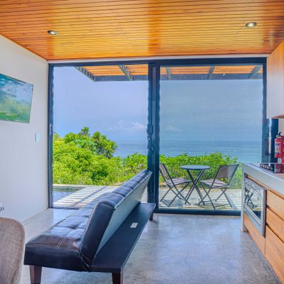 Living area with large sliding doors opening to the ocean-view terrace.