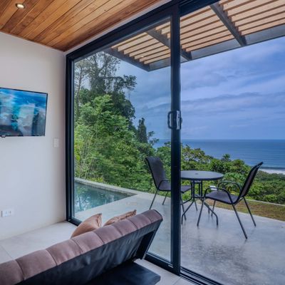 Large sliding doors fill the space with light and connect the interior to the ocean-view terrace.