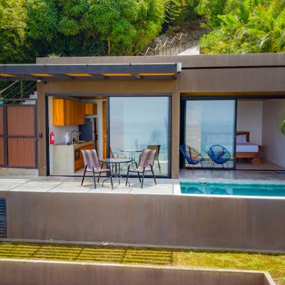 Modern villa exterior featuring a private pool, terrace, and open living area.