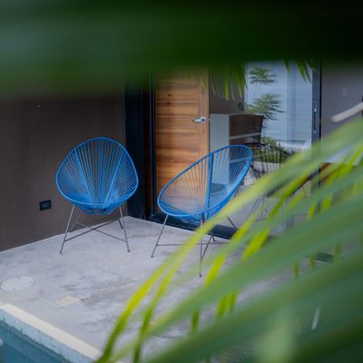 Cozy terrace seating surrounded by tropical greenery.