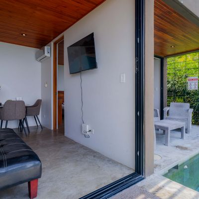 Dining area with kitchen access, air conditioning, and warm wood accents.