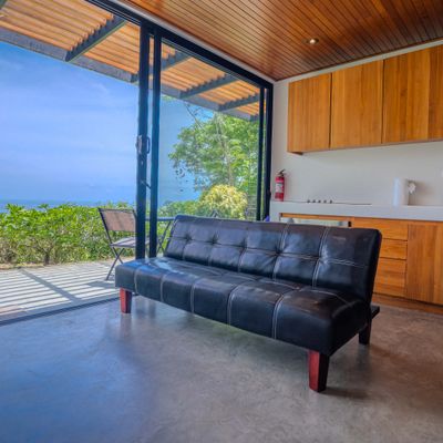 Comfortable living space with sofa, kitchen access, and ocean views.