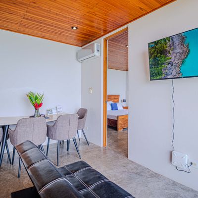 Comfortable dining and living area with TV, natural light, and modern finishes.