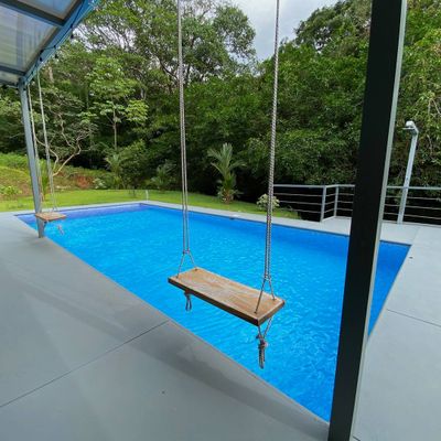 charming swing by the pool, perfect for lounging and enjoying the surroundings.