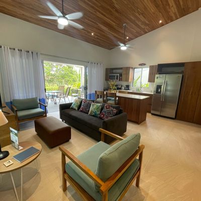 Amazing living room and kitchen with access to the patio and the pool. The living room has ceiling fan.