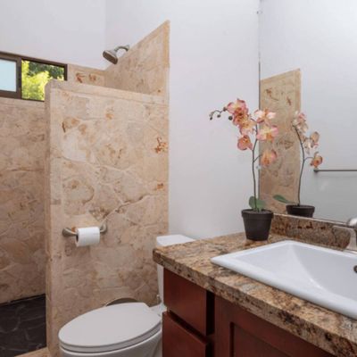 An organized, modern bathroom with a spacious shower, minimalist decor, and thoughtful lighting.