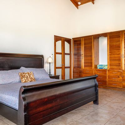 Owner's Suite has king-sized bed, en-suite bathroom, private patio/pool access, air conditioning, ceiling fan, office desk.