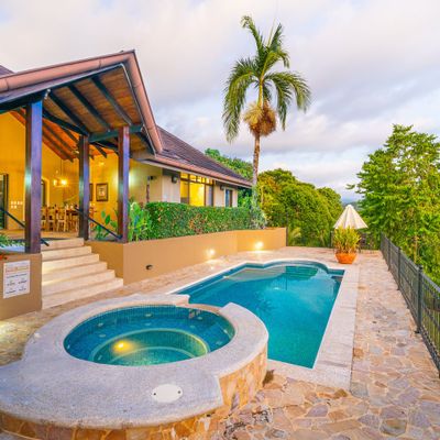 The soft afternoon light bathes the house and pool, creating a warm, inviting glow.