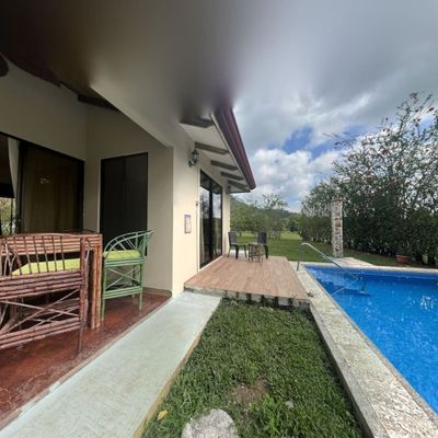 The pool area is framed by a beautiful garden, offering both privacy and serenity.