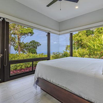 Suite #1 - Amazing views of the ocean, sunset,  swimming pool, waterfall and patio from the king-size bed, A/C, ceiling fan, en-suite bathroom with shower, bathtub, and sinks.
