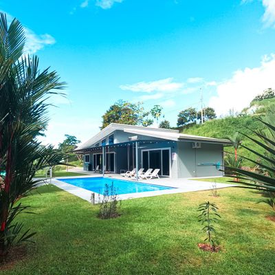 The house is surrounded by flourishing vegetation, adding beauty and privacy.