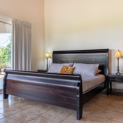 Owner's Suite has king-sized bed, en-suite bathroom, private patio/pool access, air conditioning, ceiling fan, office desk.
