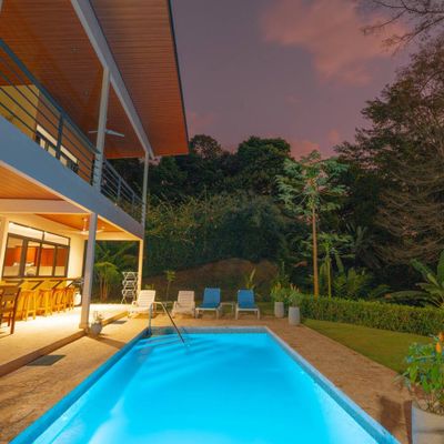 The house and pool glow beautifully at night, with soft lighting creating a tranquil ambiance.
