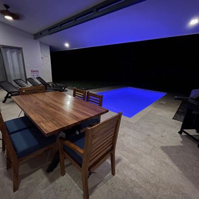 Incredible pool area with new wooden table and chairs.