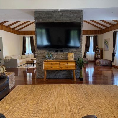 Large TV and living room in Main House on second floor with balcony.