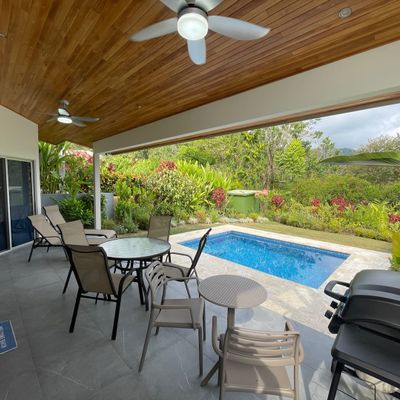 An inviting poolside space featuring comfortable outdoor seating and a BBQ grill.