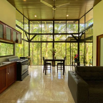 Floor to ceiling windows illuminates the open floor plan of the dining, living room and kitchen area.
