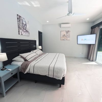 The master suite offers panoramic views of the pool, blending comfort and relaxation.