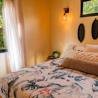 A stylish master bedroom with expansive windows that bring the beauty of nature inside.