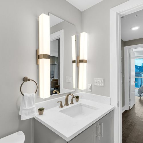 Elegant bathroom with modern lighting and a serene bedroom view.