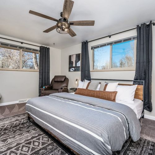 - spacious king bedroom with modern fan soft area rug and dual windows for light
- sleek wood frame bed with accent pillows and a comfy recliner chair nearby
- restful retreat for couples or solo guests wanting space and serenity