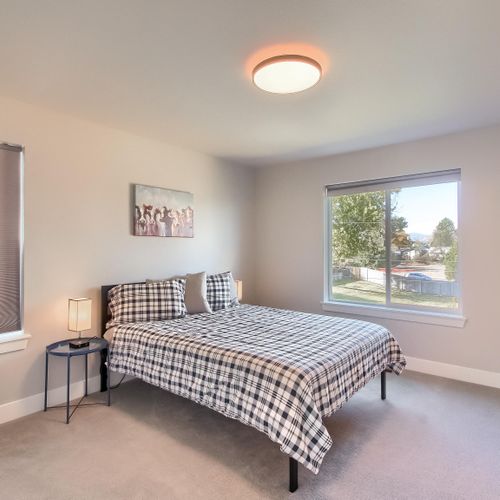 - bright and simple guest bedroom with checkered bedding and playful artwork