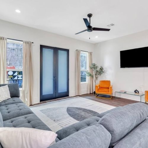 Laid-back living room w/ smart TV, blue accent wall & comfy seating for all.