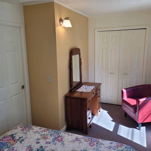 BEDROOM #1:  Features a queen-size bed, dresser, closet, and chair.