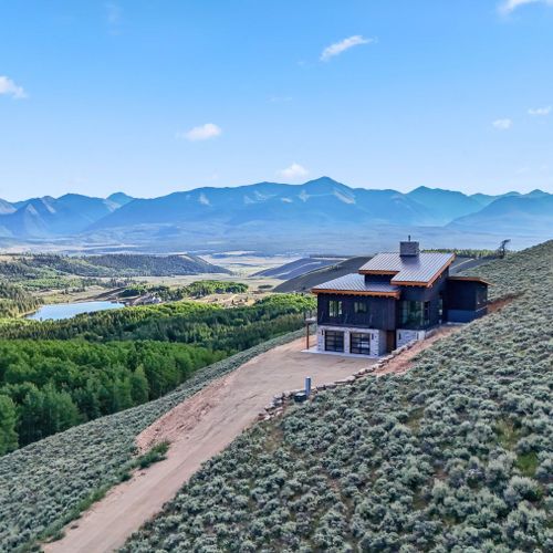Picturesque home exterior framed by the rockies and open skies.