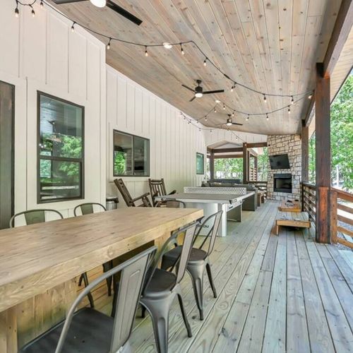Outside on the covered patio there is a large dining table, seating 8.