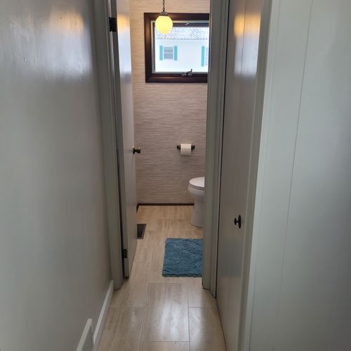 Bathroom #2:  cute little half-bathroom with toilet, sink, vanity, and mirror located near the rear door out to the deck.