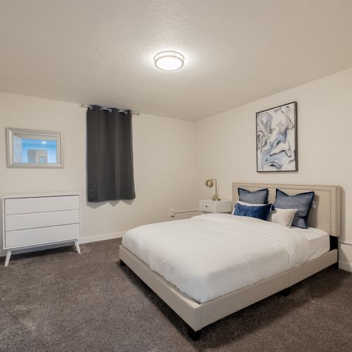 The second bedroom downstairs features a cozy queen bed and spacious closet. There's a dresser, luggage rack and plenty of shelving in the closet for your belongings.