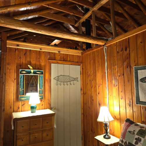 Bedroom #2:  this bedroom is at the front of the cabin from off the living room and features a full-size bed, nightstand, lamp, dresser, mirror, and closet.