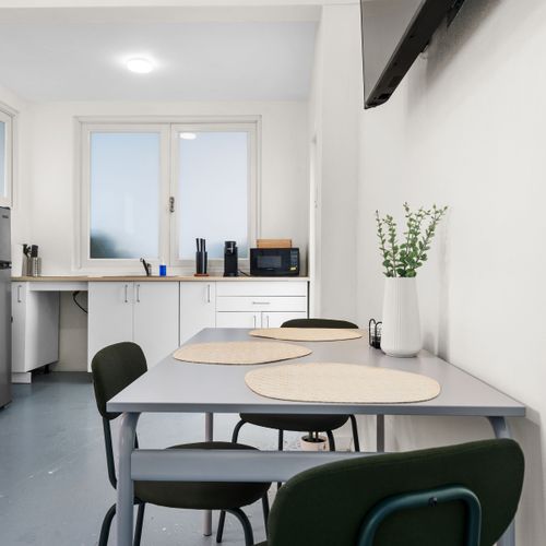 Easily reheat leftovers or prepare light dishes in this handy kitchen with a fridge, sink, microwave, and dining space.