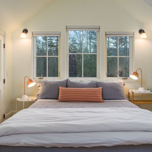 A calm and cozy bedroom with soft lighting and peaceful forest views for restful nights.