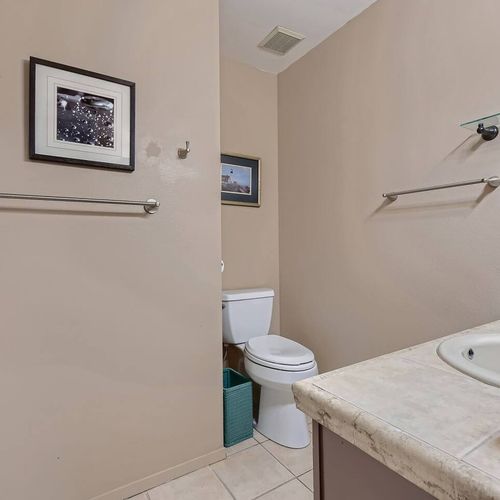 This spacious ensuite bathroom offers extended counter space and is stocked with basic toiletries for convenience.