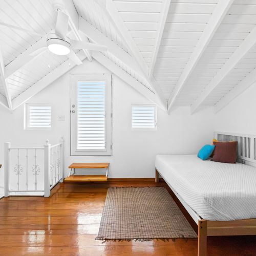 Cozy and clean bedroom with soft linens, air-conditioning, and serene white decor – your peaceful home base for a restful sleep.