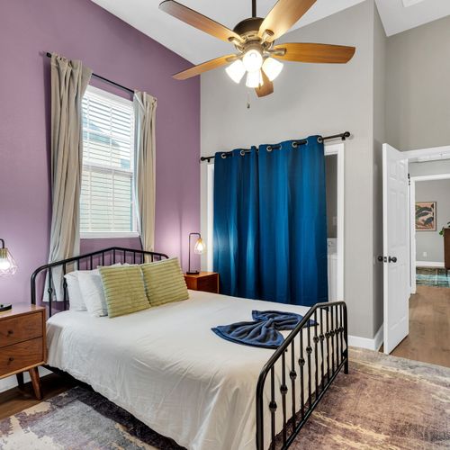 Cheerful bedroom w/ a bed, teal curtains & colorful accents for a lively stay.