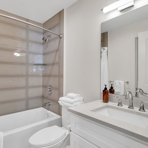 Clean and bright with sleek finishes, this bathroom offers a full tub/shower combo, fresh towels, and all the essentials for a relaxing stay.