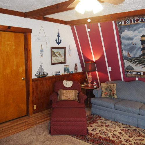 Living room:  includes a sofa, comfy chairs, live-streaming television, and entrance out to the deck.