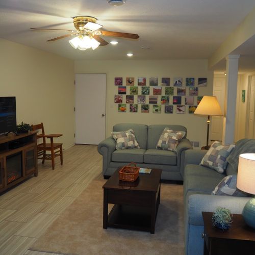 Living room:  the apartment has a very comfortable living room with a sleeper sofa, comfy chair, ceiling fan, table, and television.