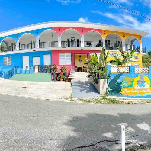 Discover the vibrant charm of our property's exterior! With its cheerful colors and inviting atmosphere, you'll feel the spirit of the island the moment you arrive.