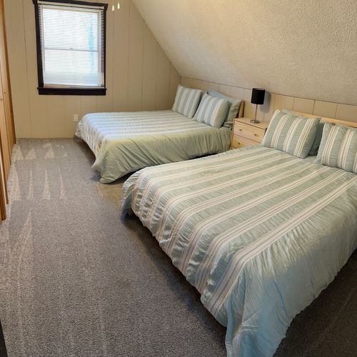 Bedroom #3 (upstairs):  features two queen beds, a ceiling fan, a nightstand, a lamp, and 2 large closets.