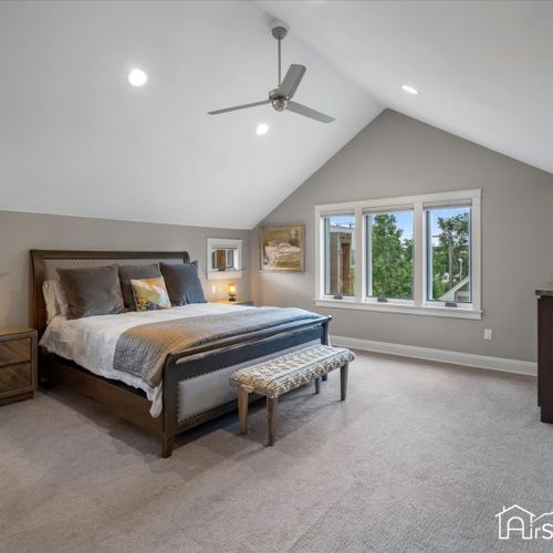 The upper level contains a large primary suite with vaulted ceilings and custom walk-in closet.