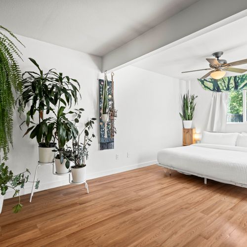 Bright master suite with king bed, garden views, and naturally fresh, plant-filled ambiance.