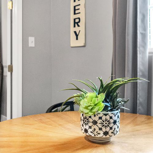 Airy dining nook w/ a potted plant & natural light flowing through the space.