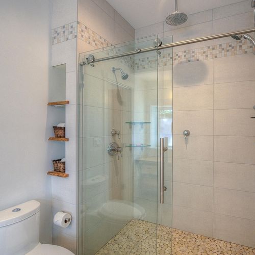 Double shower heads in a custom tiled shower.